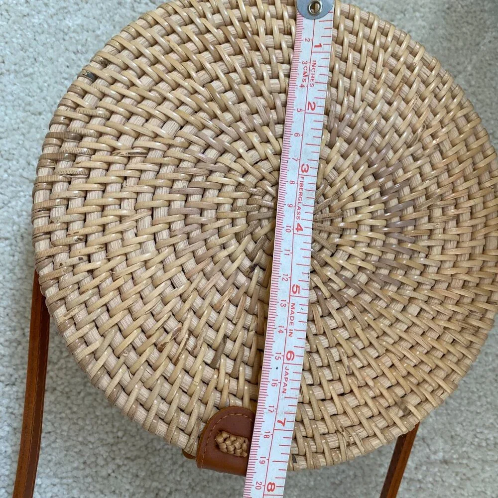 Round solid rattan woven crossbody purse cloth lined, leather accents.